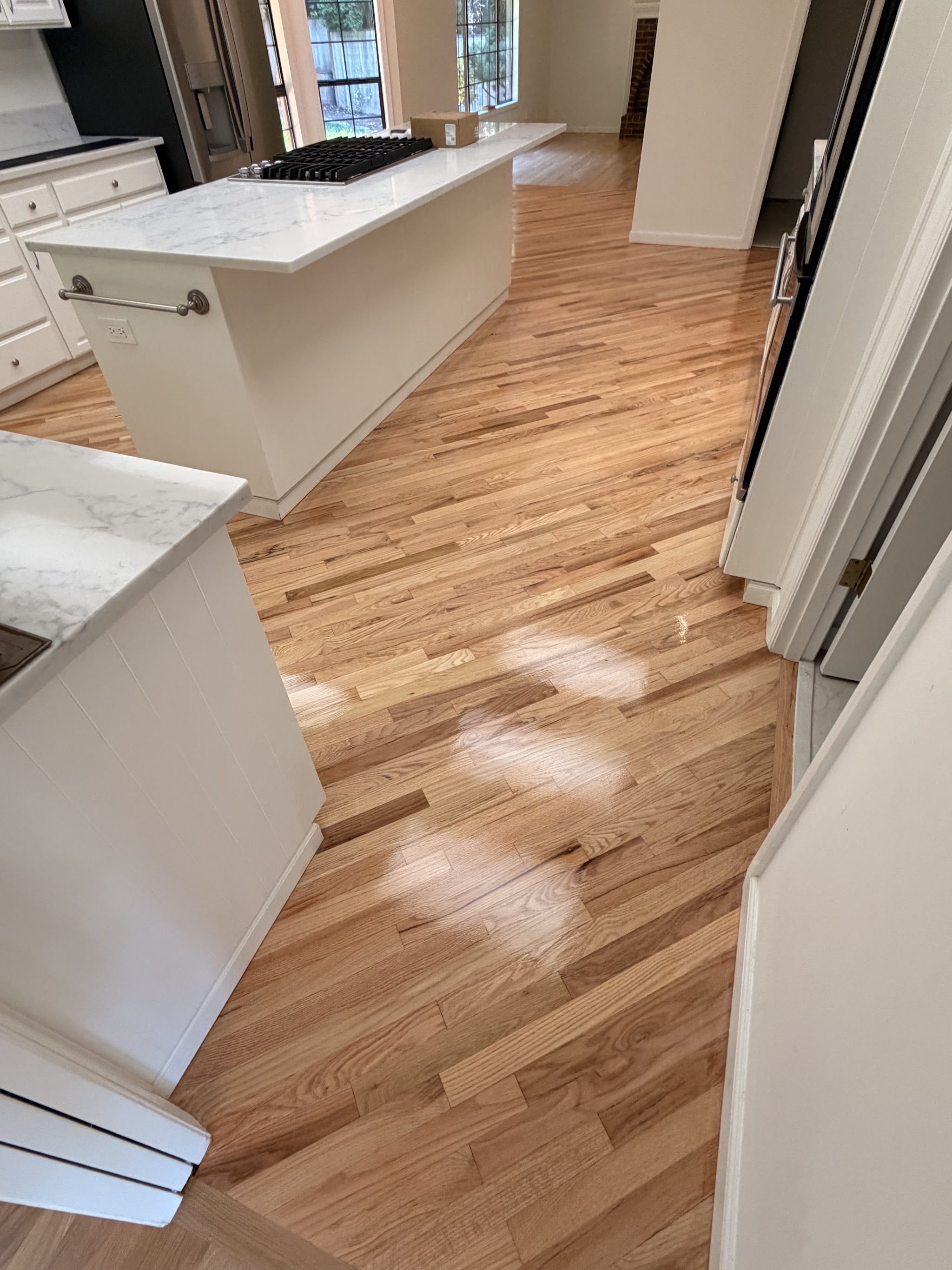 Hardwood flooring installed through a kitchen around the island